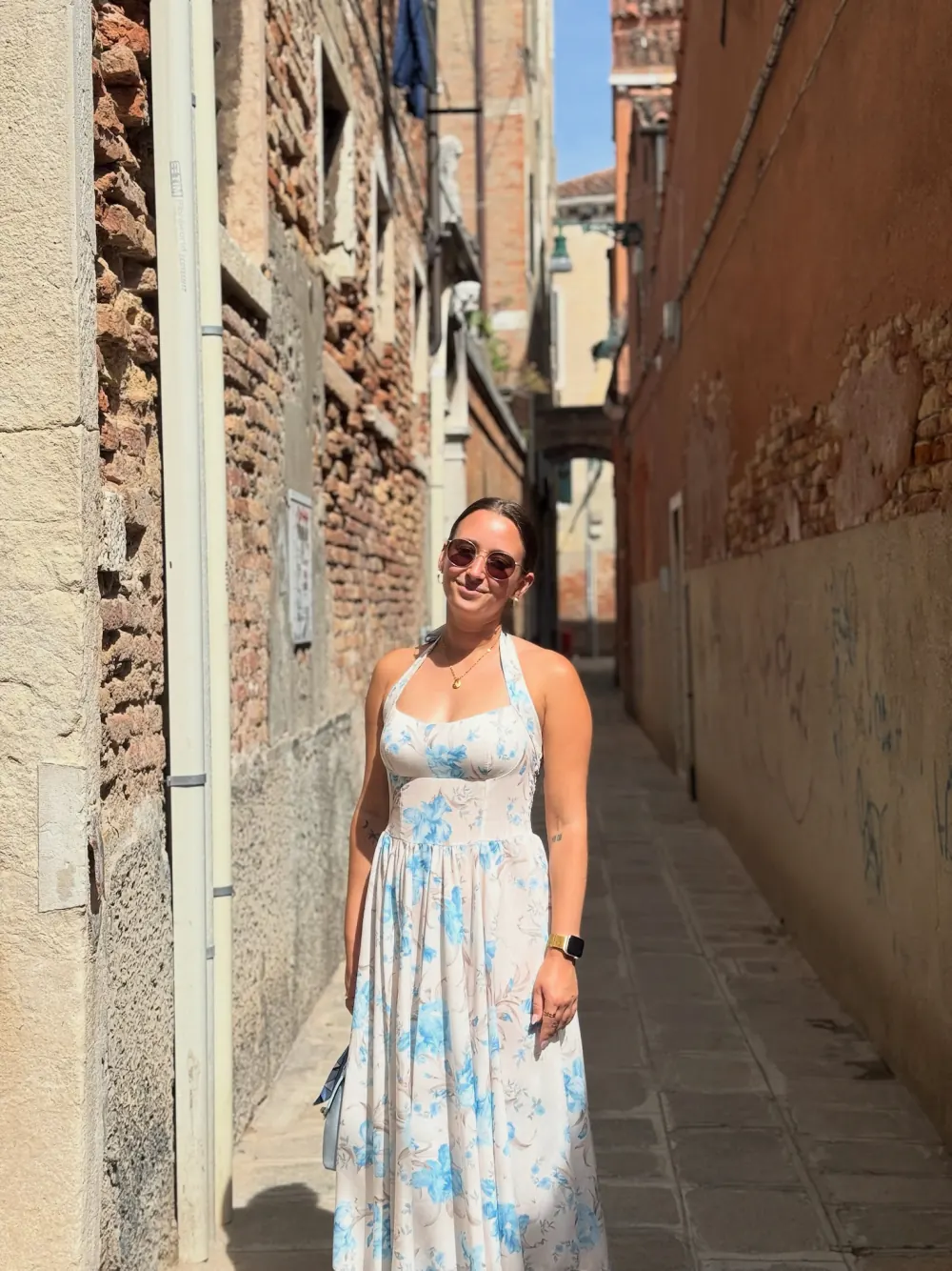 Prisca Cerny im Sommerkleid in einer schmalen Gasse in Venedig